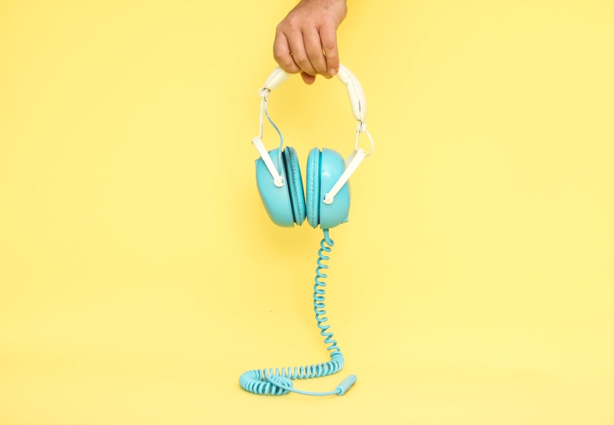 ThinkLab shares top design podcasts | hand holding headphones 