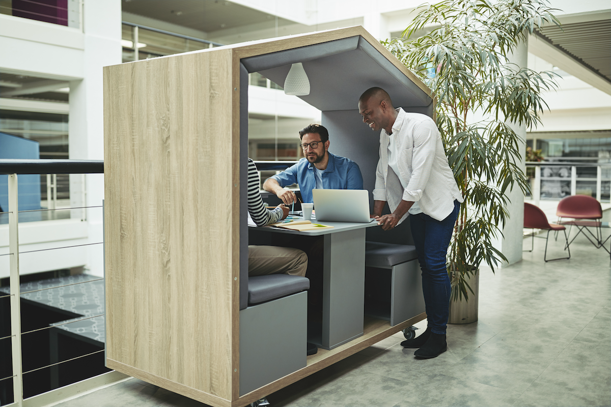 ThinkLab examines the effect of hybrid work on office spaces and the 5 biggest opportunities for workplace design | Image: men sitting in a private work station in an office 